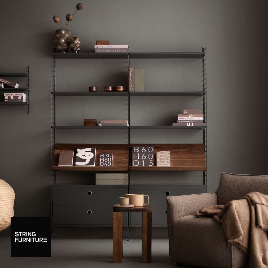 Modern bookshelf with decorative items against a gray wall, featuring String Furniture logo.