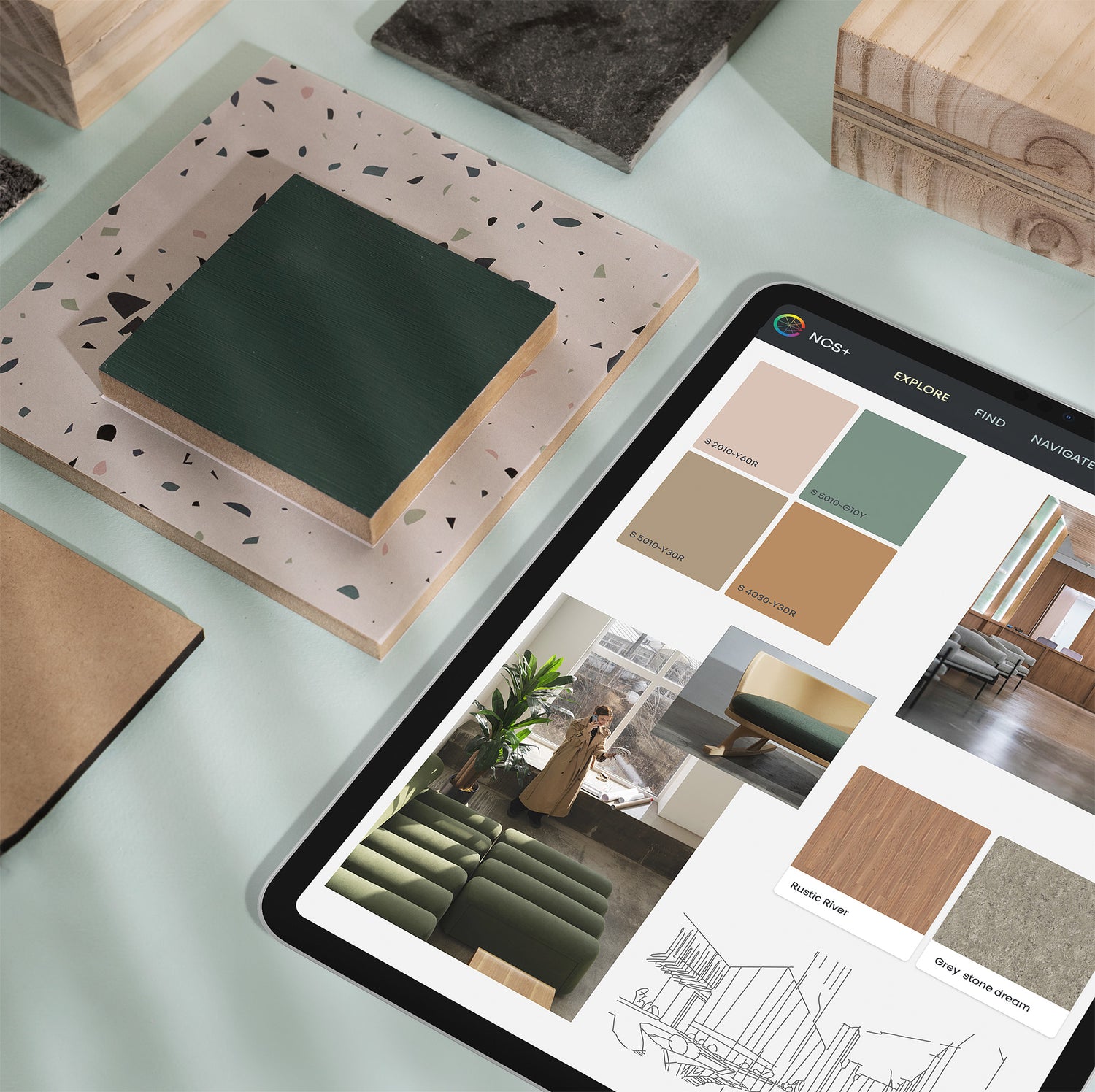 A tablet showing a moodboard in the NCS+ app with matching physical material samples