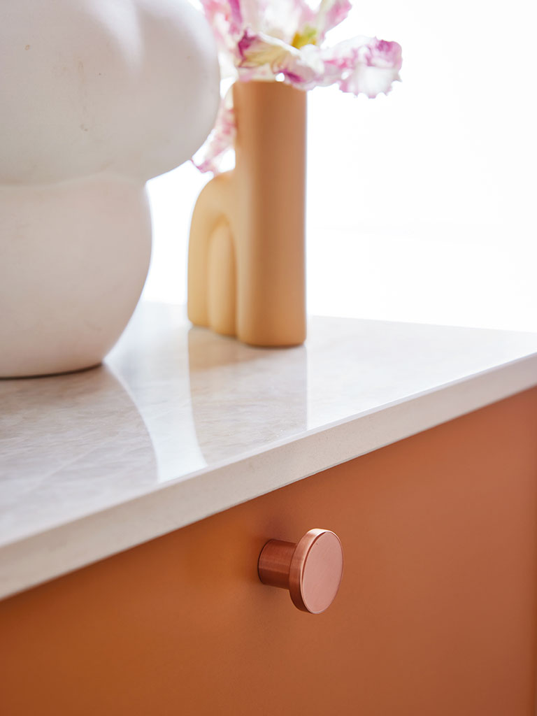 Drawer front in NCS S 3030-Y40R combined with copper knobs.