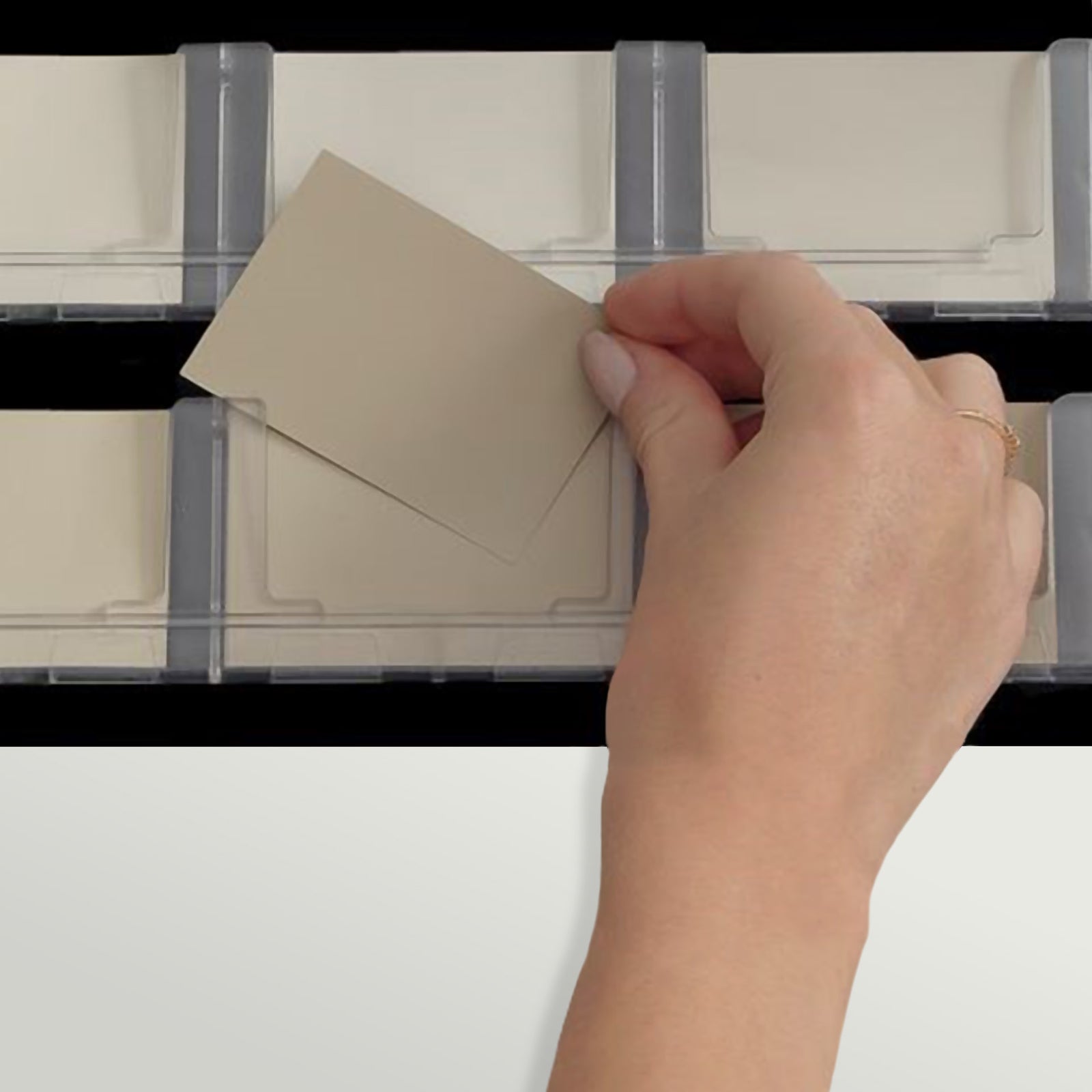 Hand selects a beige display sample