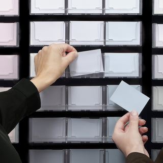 Hands displaying NCS Low Chromatic 252 Display samples